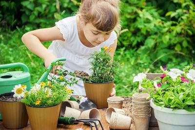 Portrait of cute girl picking potted plants