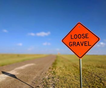 Close-up of road sign against sky