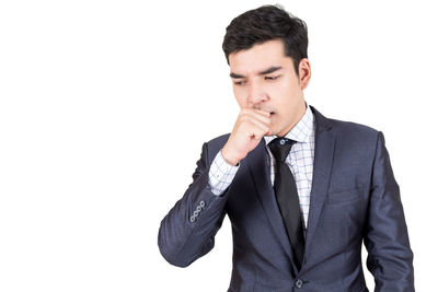 Young businessman coughing against white background