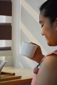 Portrait of young woman reading book at home