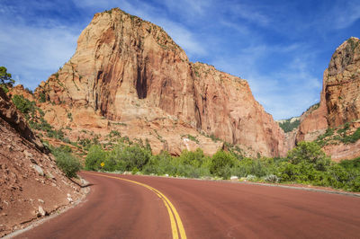 Road leading towards mountains against sky