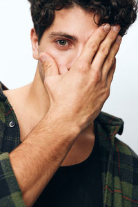 Portrait of young man standing against white background