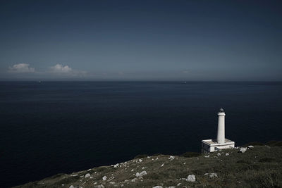 Lighthouse by sea against sky