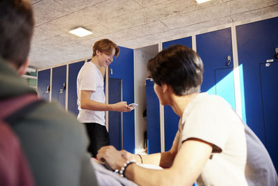 Teenage boys using cell phone in locker room