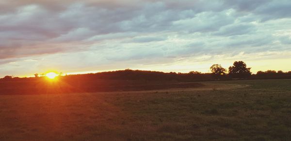 Scenic view of field against sky during sunset