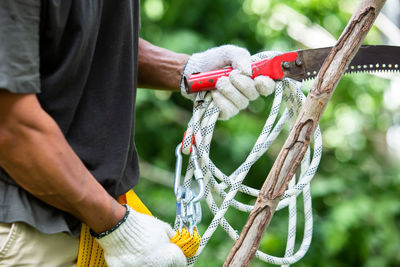 Midsection of man holding rope