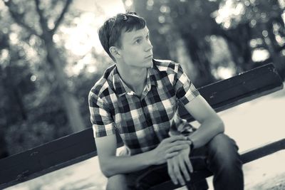 Tilt shot of man sitting on bench at park