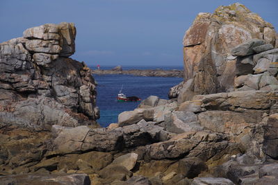 Rock formation by sea against sky