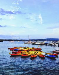 Sailboats moored in sea against sky