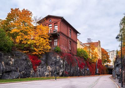 Street amidst buildings against sky during autumn