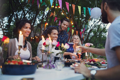 Multi-ethnic friends enjoying meal in back yard at garden party