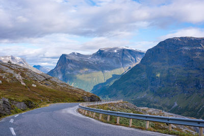 Road leading towards mountains against sky