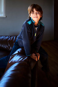 Portrait of young woman sitting on sofa at home