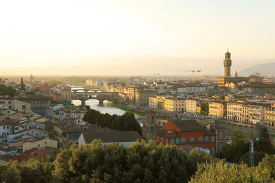 Florence city during golden sunset. view of river arno with palazzo vecchio palace, florence, italy.