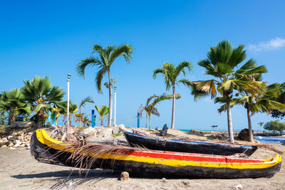 View of boats on shore against blue sky