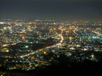 High angle view of illuminated buildings against sky at night