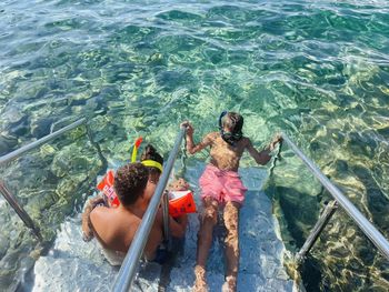 High angle view of boys and girl swimming in sea