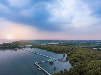 High angle view of city by sea against sky