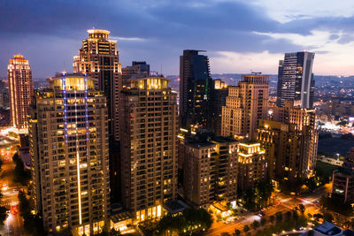 Illuminated buildings in city against sky at night