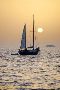 Sailboat sailing on sea against sky during sunset