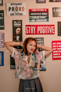 Portrait of woman standing against wall