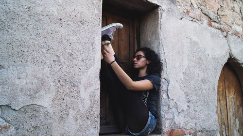 Young woman standing against wall