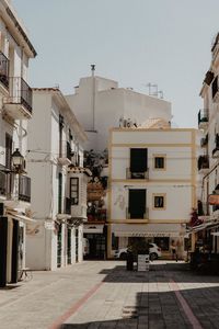 Street amidst buildings against clear sky