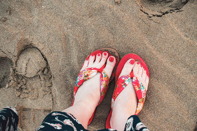 Low section of woman on sand at beach