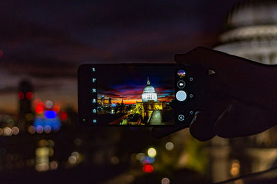 Close-up of hand using mobile phone at night