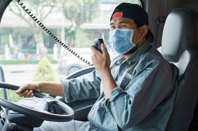 Man using mobile phone while sitting in bus