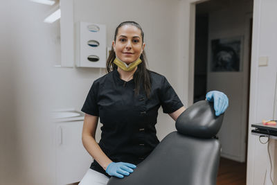 Female dentist standing in office