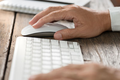 Close-up of man using laptop on table