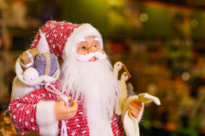 Close-up of santa claus doll, santa claus statue with christmas decorations