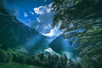 Scenic view of waterfall in forest against sky