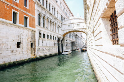 Arch bridge over canal amidst buildings