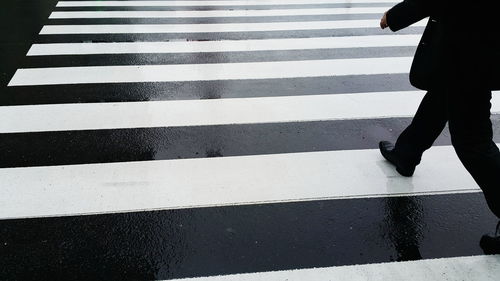 Low section of woman walking on zebra crossing