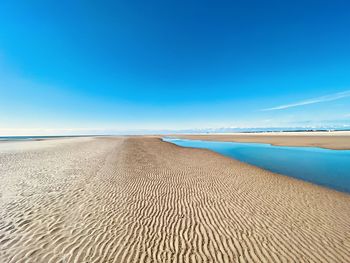 Surface level of beach against blue sky