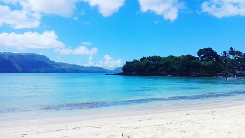 Scenic view of beach against blue sky