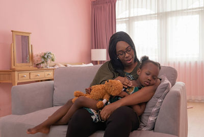 Mother and daughter sitting at home