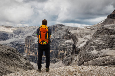 Rear view of hiker standing against dolomites