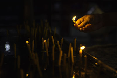 Person burning candles in temple