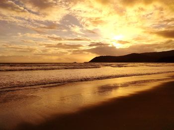 Scenic view of beach against sky during sunset