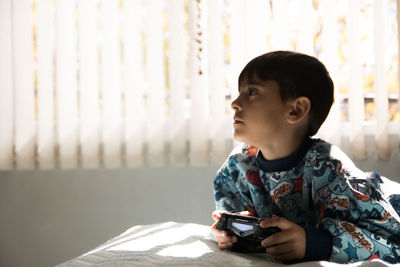 Boy looking away while using joystick 