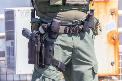 Midsection of man holding gun