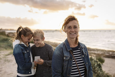 Portrait of smiling mother with children at beach