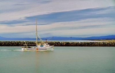 Boat sailing in sea against sky