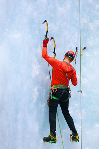 Full length of man climbing glacier