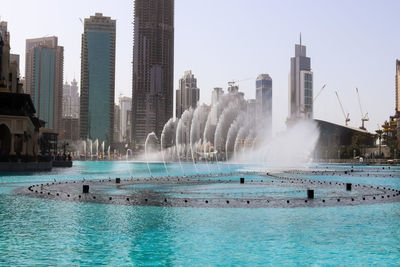 Panoramic view of swimming pool by buildings against sky