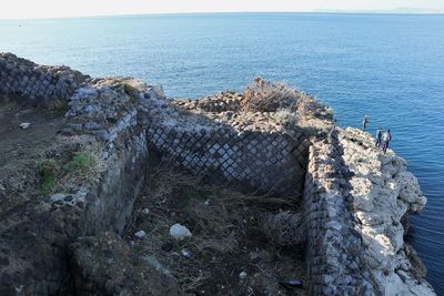 High angle view of rocks by sea against sky