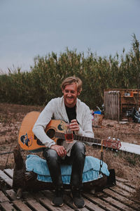 Portrait of a smiling young man playing guitar